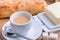 Breakfast, a mug of coffee close-up, an oil can with butter and fresh ciabatta on a cutting board