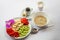 Breakfast of oats, a plate of fruit decorated with a orchid, yogurt and coffee on a white background