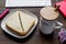 Breakfast in office with cocoa and sandwich on wooden desk