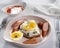 Breakfast with Open sandwich with sliced â€‹â€‹sausages, cottage cheese and boiled eggs on a light plate.