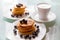 Breakfast pancakes on the stylish plate served with fresh blueberries and topped with original maple syrup, next cup of cofee