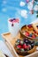 Breakfast by the pool with fruits and berries in wooden bowls: waffles, milkshake, strawberries, raspberries, blueberries,