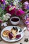 Breakfast of quark pancakes, black currant custard, currants and a bouquet of wild flowers on a wooden background