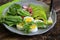 Breakfast salad with radishes, boiled egg and mix lettuce leaves,spinach. Food background. Top view