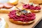 Breakfast sandwiches with boiled grated beets and walnuts on a piece of white baguette