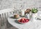 Breakfast served table - granola, milk, fresh raspberries and strawberries in the bright kitchen. Flat lay