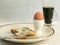 Breakfast spread with a buttered toast, boiled egg on an egg cup and a glass of coffee