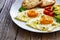 Breakfast - sunny side up egg, toasted bread and avocado served on wooden table