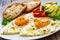 Breakfast - sunny side up egg, toasted bread and avocado served on wooden table