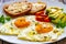 Breakfast - sunny side up egg, toasted bread and avocado served on wooden table