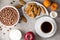 Breakfast table with coffee, ginger cookies, chocolate cereal balls, milk and fruits on stone background.