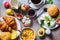 Breakfast table with cornflakes, croissants, fruit, cheese and cup of coffee. Dark background, top view