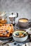 Breakfast table with granola and yogurt, homemade belgian waffles and cup of hot black coffee