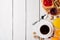 Breakfast table with healthy tasty ingredients. Coffee, toast, jam, almonds, orange juice and fruit on white wooden background.