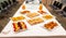 breakfast table prepared with sandwiches, fruit skewers, orange juice, coffee and glasses