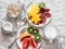 Breakfast table. Variety of fruits - mango, kiwi, grapefruit, orange and greek yogurt, oat flakes on a light background, top view.