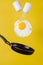 Breakfast time. A fried egg and a frying pan with salt shakers levitate in the air on a yellow