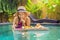 Breakfast tray in swimming pool, floating breakfast in luxury hotel. Girl relaxing in the pool drinking smoothies and
