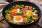 Breakfast for two. Fried eggs with vegetables - shakshuka in a frying pan