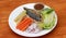 Breakfast in the white round plate. Fried mackerel and Rice with Spicy Shrimp Paste Dip and vegetable, Chinese cabbage, baby corn