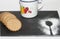 Breakfast with wholemeal cookies, a jug of milk and the silhouette of a cooking spoon on a black table