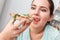 Breaking Diet. Chubby girl sitting at kitchen table with slice of pizza tongue out excited close-up