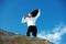 Breaking free from the 9 to 5 routine. Low-angle view of happy businessman standing on a rock with his hands in the air