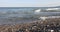 Breaking wave sand and beach stones on shore