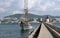 Breakwater of the dock of the port of the Ibiza island with a small red lighthouse and a nice sailboat