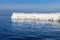 The breakwater in the form of an iceberg in a Sunny winter day.