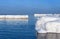 The breakwater in the form of an iceberg in a Sunny winter day.