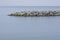 The breakwater in the form of a strip of stones stretches out into the sea