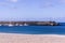 Breakwater with a lighthouse on it and moored yachts