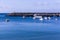 Breakwater with a lighthouse on it and moored yachts