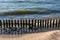 A breakwater made of logs cuts through the sea wave