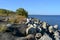 Breakwaters on the bank of Volga river. Landscape with stones, trees and bridge over the river