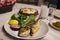 Bream fish on the plate at the dinner table with Turkish Raki.