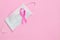 Breast Cancer concept : Top view pink ribbon and protective mask symbol of breast cancer campaign on pink