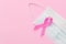 Breast Cancer concept : Top view pink ribbon and protective mask symbol of breast cancer campaign on pink