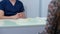 Breast implants on table in medical clinic with unrecognizable doctor and patient shaking hands sitting indoors. Middle