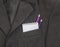 Breast pocket dark black man`s jacket a bright strip of pencils of purple and lilac color and notebook on the springs in the cage