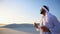 Breath of freshness of male Muslim in middle of dry climate of sandy desert. guy Arab drinks water from glass in open