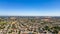 A breathtaking aerial view of Antioch, California: houses nestled amidst verdant hills, crisscrossed by meandering streets, all