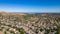 A breathtaking aerial view of Antioch, California: houses nestled amidst verdant hills, crisscrossed by meandering streets, all