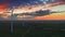 Breathtaking aerial view of wind turbines on field with at dusk