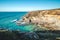 Breathtaking cliffs with crashing waves in the afternoon sun on the Atlantic coast near Vila Nova de Milfontes, Odemira, Portugal