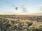 Breathtaking drone view of hot air balloons flying over the Red Valley in Cappadocia in Turkey at dawn. Fairy chimneys