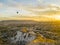 Breathtaking drone view of hot air balloons flying over the Red Valley in Cappadocia in Turkey at dawn. Fairy chimneys