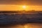 Breathtaking golden sunset over the stormy sea with huge waves