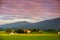 Breathtaking lansdcape of Austrian countryside on sunset. Dramatic sky over idyllic green fields of Anstrian Central Alps on autum